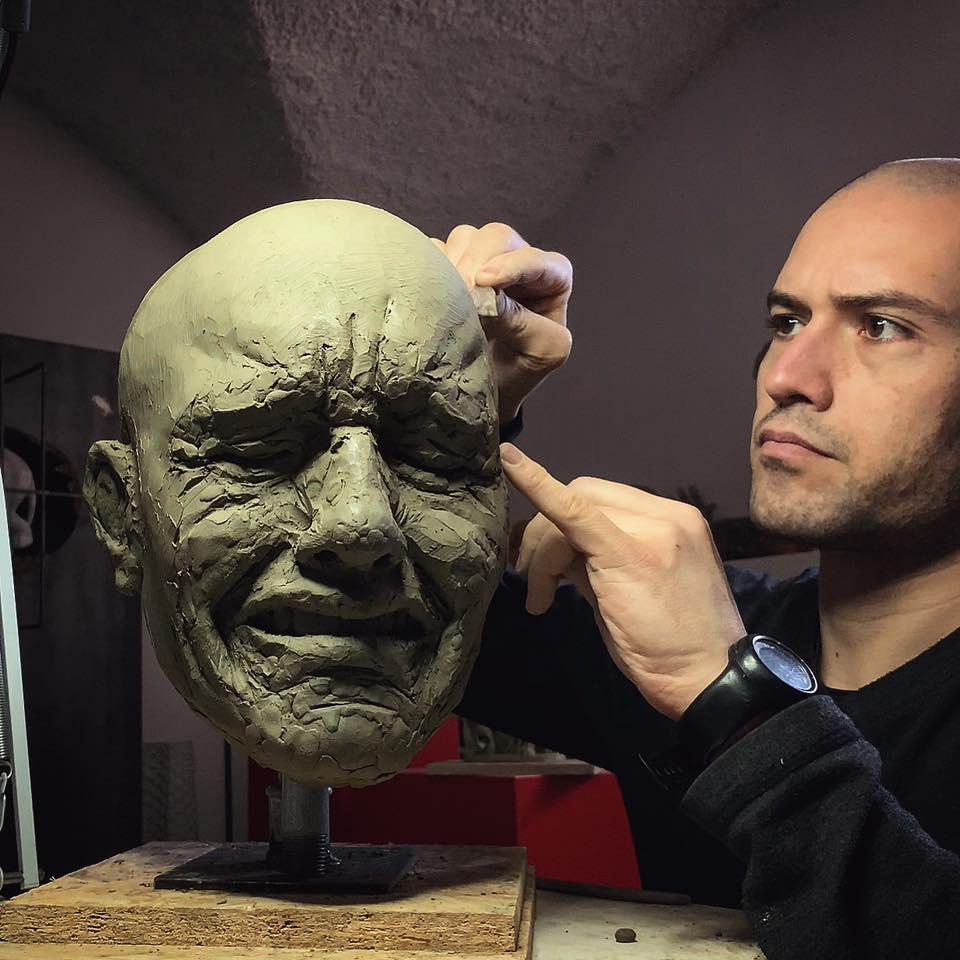 Studio d'espressione sul modello in argilla, si nota la somiglianza tra il volto modellato e quello dell'artista.